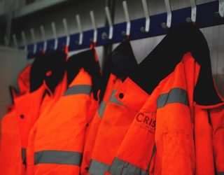 Crisp Malt hi-vis jackets on a coat rack