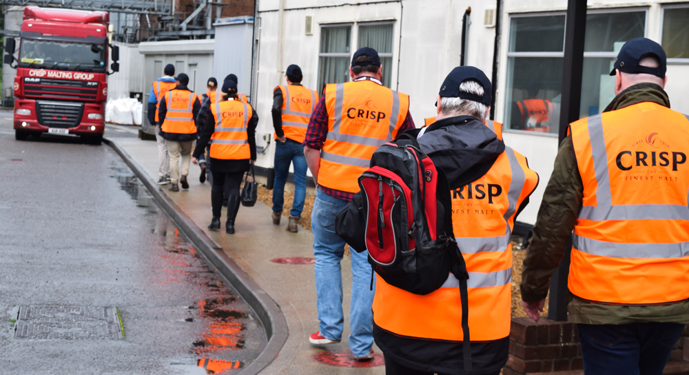 Lines of people in high vis jackets with Crisp logo walking towards lorry