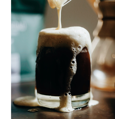 Imperial Stout being poured into a glass that's overflowing