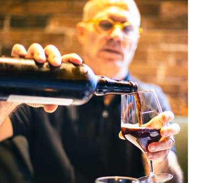 Man pouring an imperial stout into a glass from a bottle on Mike Bensons blog on Brewing Imperial Stouts.