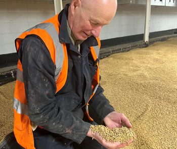 Neville kneeling down and holding malt in his hands