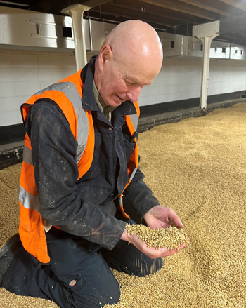 Neville kneeling down and holding malt in his hands