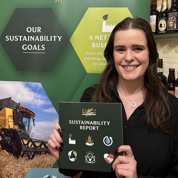 Ellie Wood, Sustainability Coordinator at Crisp Malt holds our latest Sustainability Report 2023 brochure.